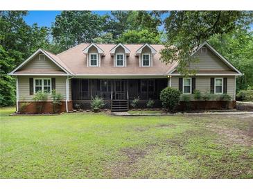 Charming home featuring a well-manicured lawn, inviting screened-in porch, and classic architectural details at 324 Kibbee Rd, Mcdonough, GA 30252