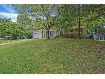 Charming brick home with a well-manicured front yard and mature trees providing ample shade at 622 Sheffield Rd, Norcross, GA 30071