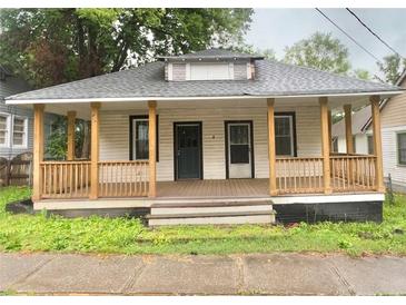Charming single-story home with a welcoming front porch and mature trees in the background at 4 Ivy St, Porterdale, GA 30014