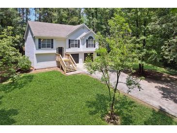 Charming two-story home featuring a manicured lawn and attached two-car garage at 835 Navajo Trl, Covington, GA 30016