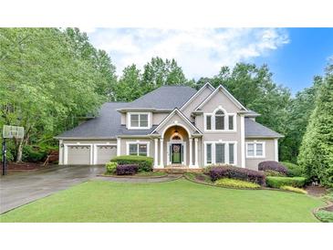 Charming two-story home featuring a three-car garage and a well-manicured front lawn at 3028 Towneside Ln, Woodstock, GA 30189