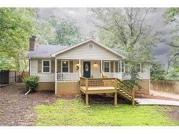 Charming home with a front porch, light siding, and a well-maintained yard at 4409 Woodward Mill Rd, Sugar Hill, GA 30518