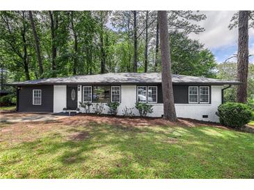 Charming renovated single-story brick home with a well-manicured lawn, set amongst mature trees at 2975 Rollingwood Se Ln, Atlanta, GA 30316