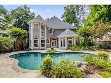 Backyard with a beautiful pool surrounded by a stone patio and lush landscaping at 1078 Shady Valley Ne Pl, Atlanta, GA 30324