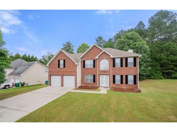 Charming two-story brick home with a well-maintained lawn and a two-car garage at 1486 Rogers Crossing Dr, Lithonia, GA 30058