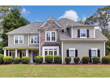 Charming two-story home with stone accents, a welcoming front porch, manicured lawn, and lush landscaping at 1501 Laurelhill Drive Southwest Dr, Lawrenceville, GA 30044