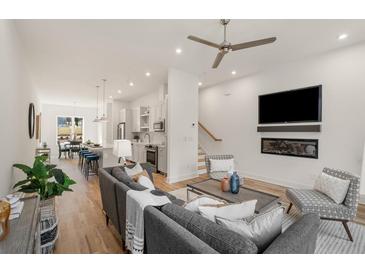 Bright living room featuring hardwood floors, modern furniture, and an open floor plan to the kitchen and dining area at 1237 Memorial Se Dr # 303, Atlanta, GA 30316