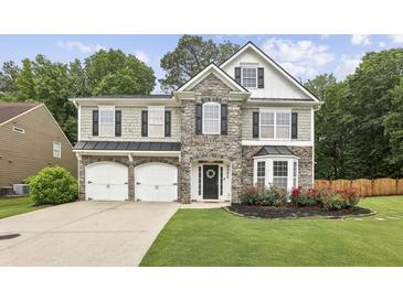 Charming two-story home with stone accents, manicured lawn, and a two-car garage at 3395 The Commons Dr, Cumming, GA 30041