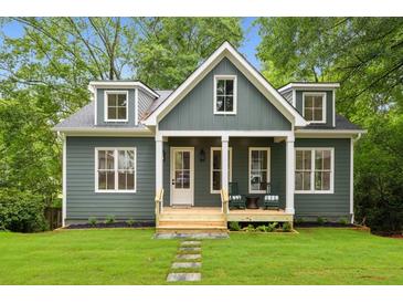 Charming exterior view of a two-story home with a manicured lawn and inviting front porch at 2760 Fraser Se St, Smyrna, GA 30080