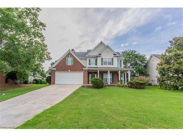 Charming two-story home with a brick facade, white siding, and a well-manicured lawn at 806 Chelsea Wood Ct, Stockbridge, GA 30281