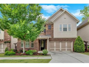 Charming two-story home featuring brick and siding, a well-manicured lawn, and an attached two-car garage at 12 Pine St, Roswell, GA 30075