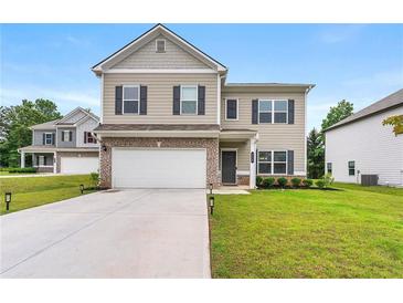 Charming two-story home featuring neutral siding, brick accents, a two-car garage, and a well-maintained lawn at 228 Whitneys Way, Dallas, GA 30157