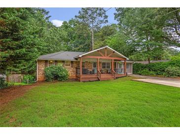 Charming brick home featuring a welcoming front porch and lush green lawn at 3510 Dunn Se St, Smyrna, GA 30080