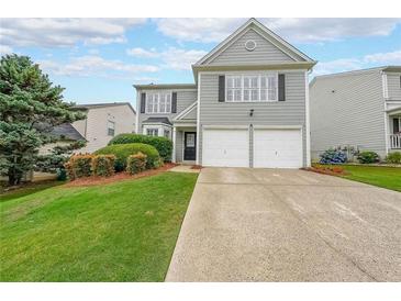 Charming two-story home with a well-manicured lawn and a two-car garage at 626 Dahoma Trail Trl, Woodstock, GA 30188