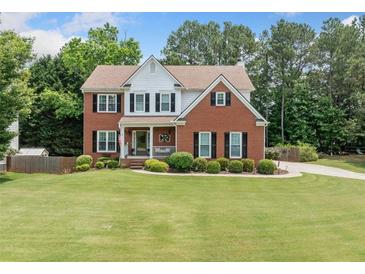 Beautiful two-story brick home with a well-manicured lawn and mature trees at 1975 Fairway Close Ter, Lawrenceville, GA 30043