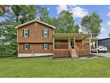 Charming two-story home featuring wood siding, a covered porch and a well-manicured lawn at 860 The Cir, Lawrenceville, GA 30043