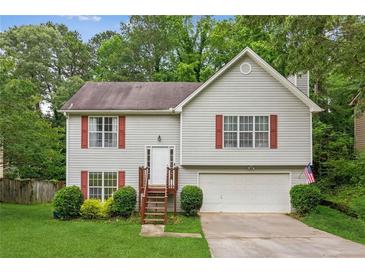 Charming two-story home with gray siding, red shutters, a well-manicured lawn and mature trees at 5519 Princeton Oaks Ln, Sugar Hill, GA 30518