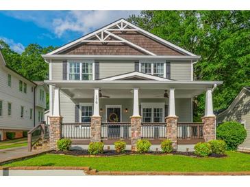 Charming two-story home featuring a welcoming front porch with stone pillars and landscaped yard at 176 Olympic Pl, Decatur, GA 30030