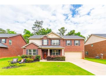 Charming brick two-story home with an attached garage and well-manicured landscaping at 12275 Styron Dr, Hampton, GA 30228