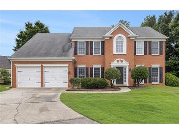 Traditional brick home with a two-car garage, manicured lawn, and mature landscaping at 505 Stedford Lane, Duluth, GA 30097