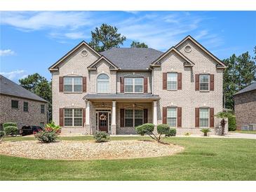Stunning two-story brick home with a well-manicured lawn and lovely landscaping in a desirable neighborhood at 6861 Louis Dr, Locust Grove, GA 30248