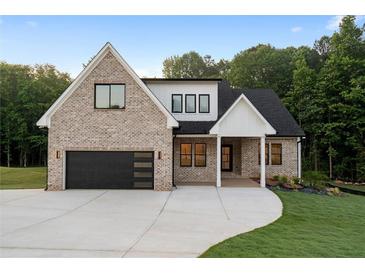 Beautiful exterior view of modern home with brick, black trim and a driveway at 863 N Bay Overlook, Villa Rica, GA 30180