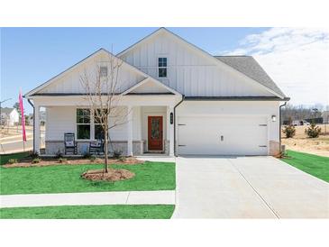 Charming single-Gathering home boasts a manicured lawn, two-car garage, and inviting covered porch at 440 Madison Lakeview Dr, Acworth, GA 30102
