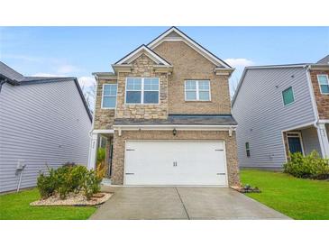 Charming two-story home featuring a brick and stone facade and a two-car garage at 826 Bentley Dr, Fairburn, GA 30213