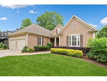 Charming one-story home featuring manicured lawn and beautiful landscaping at 6245 Hampton Golf Club Dr, Cumming, GA 30041