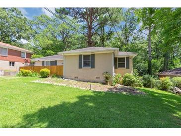 Ranch-style home with a well-maintained lawn and mature trees providing shade and curb appeal at 2702 Rollingwood Se Ln, Atlanta, GA 30316