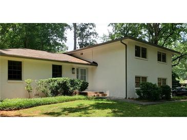 Charming, traditional-style two-story home with white brick, well-maintained landscaping, and mature trees at 4485 Lake Ivanhoe Dr, Tucker, GA 30084