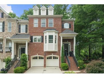 Charming brick townhome with a two-car garage and manicured landscaping at 5968 Reddington Way, Sandy Springs, GA 30328