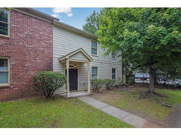 Charming home with a brick accent wall, light siding, well-manicured bushes, and a sidewalk leading to the front door at 1707 Taylor Ave, Atlanta, GA 30344