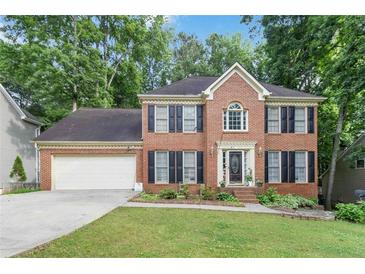 Charming two-story brick home with a well-manicured lawn and attached two-car garage at 3500 Stillwood Dr, Snellville, GA 30039