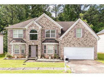 Charming two-story brick home with an attached two-car garage and well-maintained lawn at 1382 Koble Mill Ln, Riverdale, GA 30296