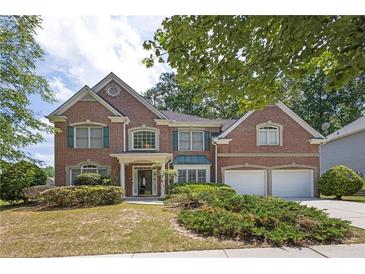 Charming two-story brick home featuring a manicured front yard and attached two-car garage at 250 Lawrence Pl, Atlanta, GA 30349
