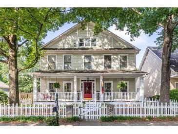 Charming two-story home with a classic white picket fence and inviting front porch nestled among mature trees at 2092 Wood Nw Trl, Atlanta, GA 30318