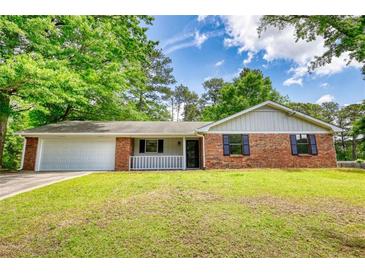 Charming brick home with manicured lawn, attached garage, and inviting front porch at 2931 Randolph Ct, Conyers, GA 30012