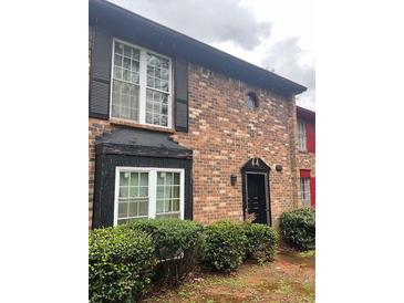 Charming brick townhome with black shutters and a well-maintained front yard offers classic curb appeal at 658 Garden Walk Dr, Stone Mountain, GA 30083