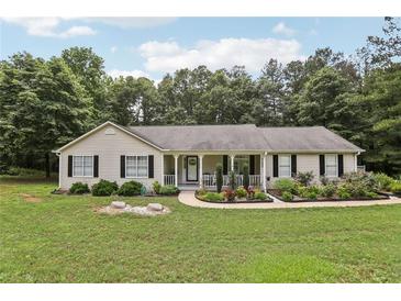 Charming single-story home with inviting front porch and beautifully landscaped front yard surrounded by mature trees at 105 Laney Ct, Mcdonough, GA 30252