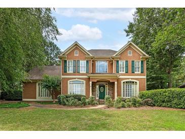 Charming two-story home with well-manicured lawn and mature trees, featuring green shutters and a covered entryway at 170 Glen Eagle Way, Mcdonough, GA 30253