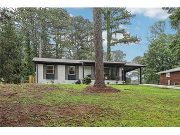 Charming single-story home featuring a cozy front porch and freshly landscaped yard with mature trees at 3351 Landrum Se Dr, Smyrna, GA 30082