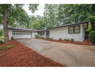 Charming single-story home featuring a brick facade, attached garage, and well-manicured front yard at 7505 Rico Rd, Chattahoochee Hills, GA 30268