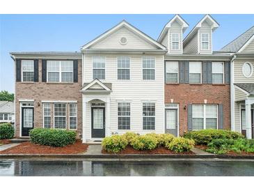 Beautiful townhouse with manicured landscaping, brick accents, and ample windows for natural light at 2709 Heathrow Dr, Lawrenceville, GA 30043