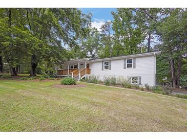 Charming home featuring a well-maintained lawn and inviting front porch with wooded surroundings at 5666 Fawn Dr, Powder Springs, GA 30127