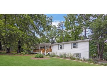 Charming home featuring a well-manicured lawn and inviting front porch with wooden stairs at 5666 Fawn Dr, Powder Springs, GA 30127