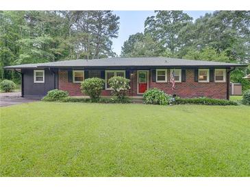 Charming single-story brick home with a vibrant lawn and manicured landscaping at 122 Vickery Dr, Fairburn, GA 30213