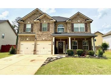 Beautiful brick home with a well-manicured lawn and a two-car garage at 558 Hideaway Dr, Jonesboro, GA 30238