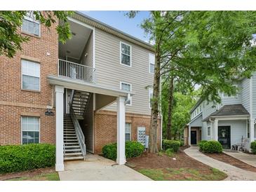 Apartment complex featuring brick and siding exterior with multiple units and stairway access, nestled among mature trees at 245 Amal Sw Dr # 2018, Atlanta, GA 30315