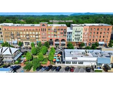 Multi-story building with visible businesses, parking, and vibrant landscaping at 360 Chambers St # 405, Woodstock, GA 30188